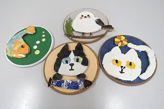 割れた食器でモザイクアート作りの作品例。円形の台に張り付けたモザイク。ネコ２種、魚、シマエナガのデザイン。